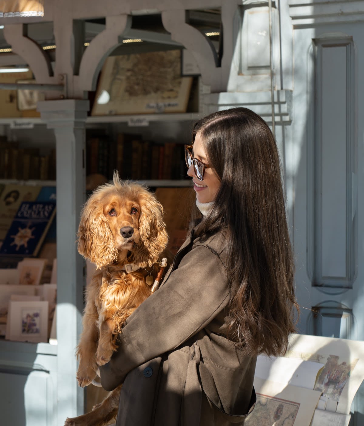Denisse holding Alba in front of a vintage bookstore in Madrid